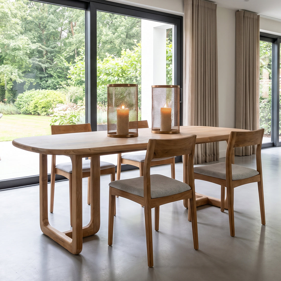 Kayu Living Freya teak dining chairs with light green fabric seats arranged around a wooden table in a bright room.