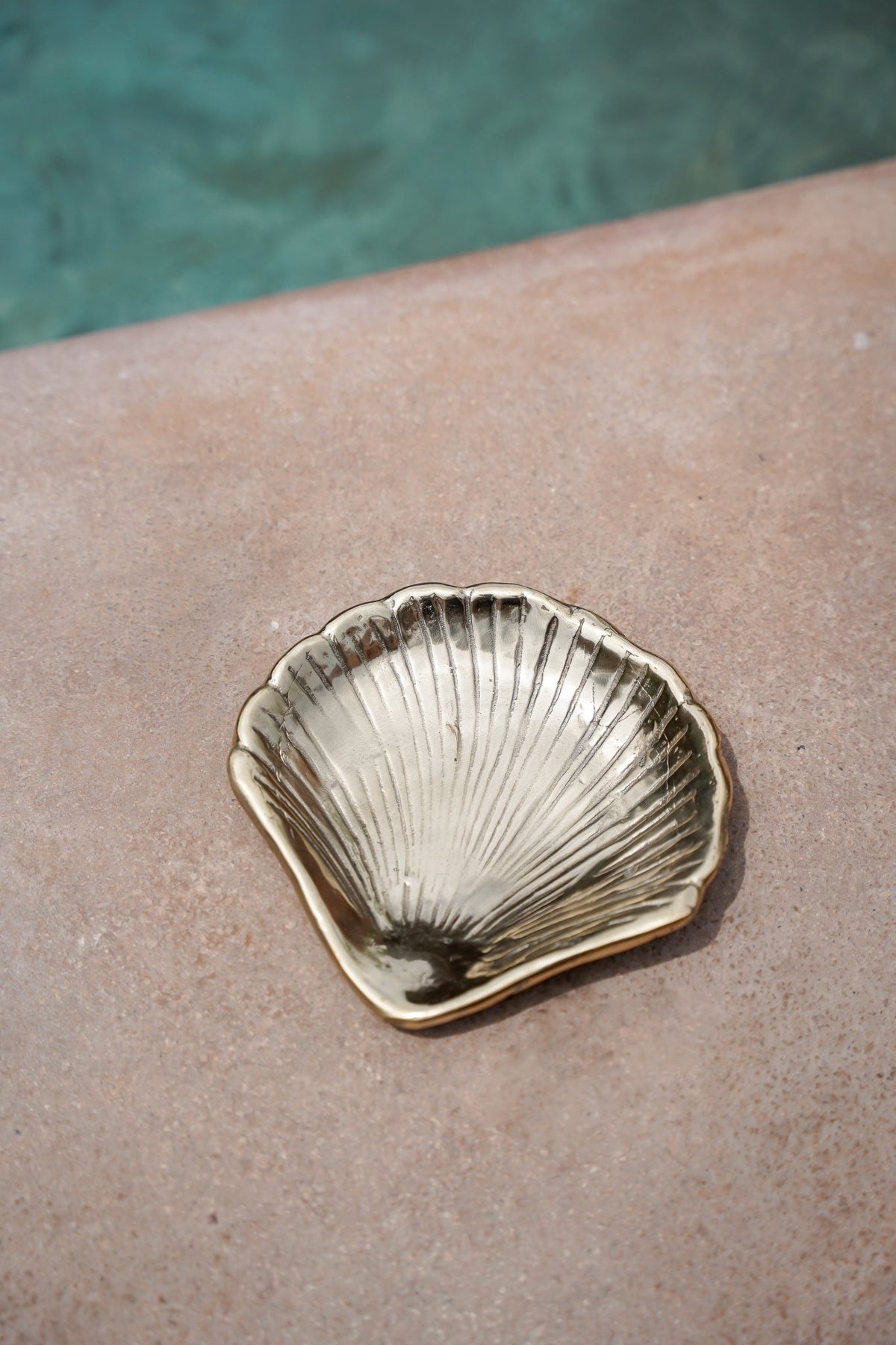 Kayu Living handmade gold brass shell dish for jewelry or keys, featuring a textured scalloped design.