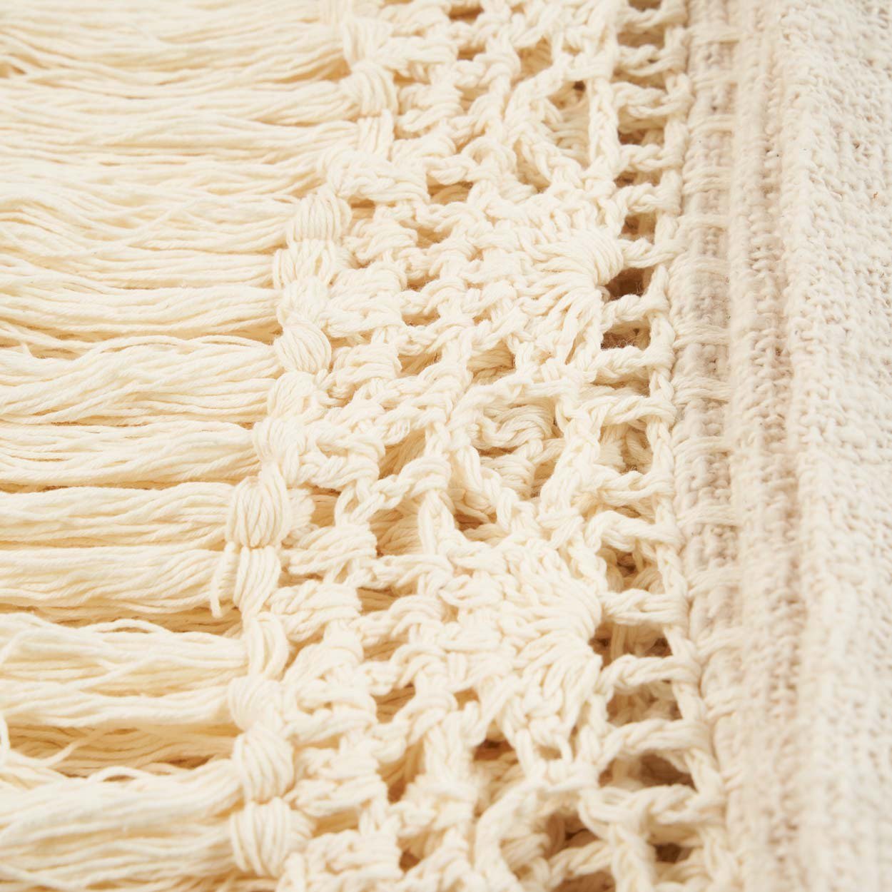 Kayu Living Gypsy Bed Throw in natural cotton featuring intricate crochet detailing and long decorative fringe edges.