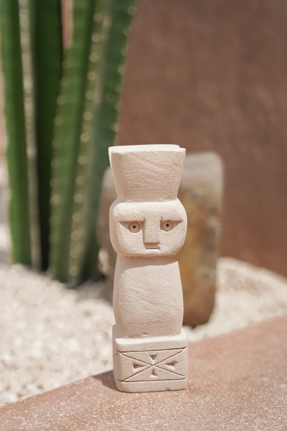 Kayu Living handmade Balinese stone guardian figurine with a natural finish and carved geometric base details.