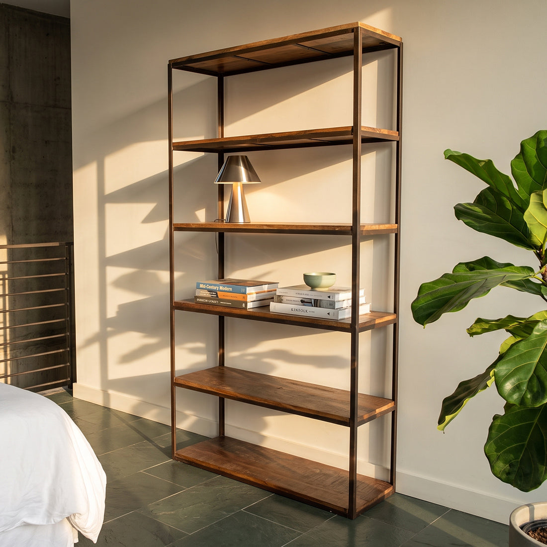 Kayu Living industrial tall iron rack with six reclaimed brown wooden shelves in a sunlit living room setting.
