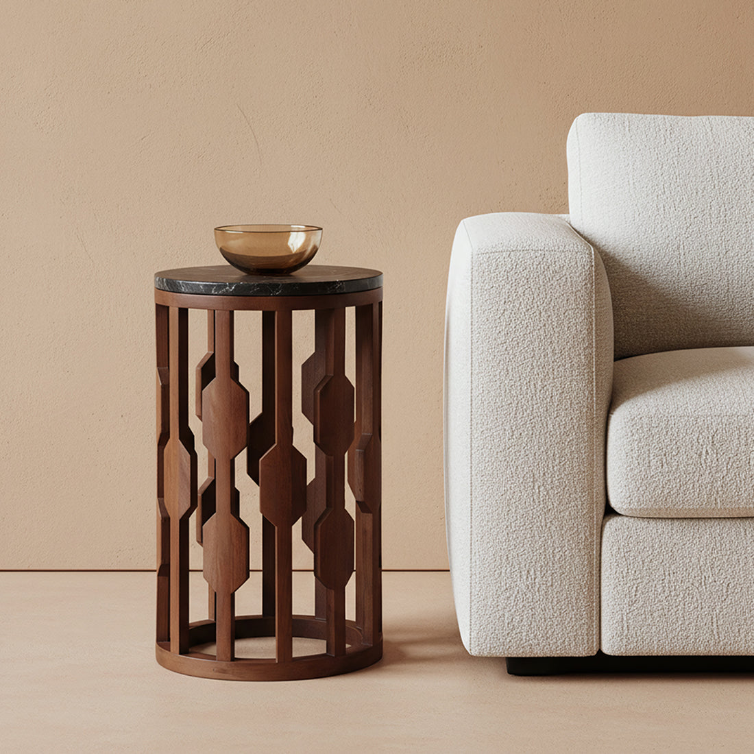 Kayu Living Lampung round side table with a black marble top and a decorative dark mango wood base next to a sofa.