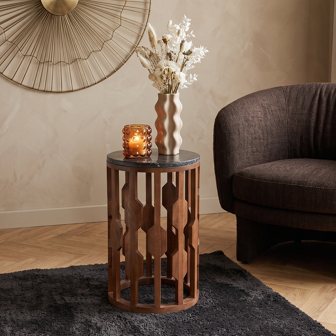 Kayu Living Lampung side table with a round black marble top and a dark mango wood base in a cozy living room.