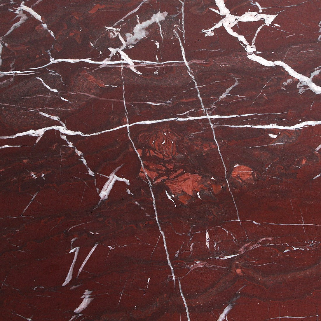 Kayu Living oval marble coffee table with deep bordeaux hues and dramatic white veining. Solid marble top on a natural mango-wood base.