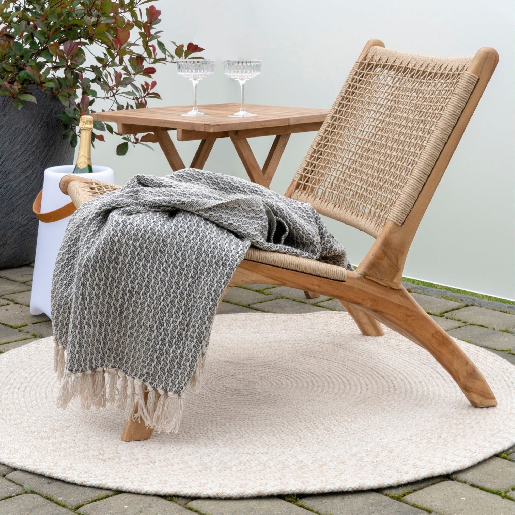 Kayu Living Menorca round rug in sand, 100% recycled plastic, Ø120 cm. Braided texture with a subtle spiral pattern.