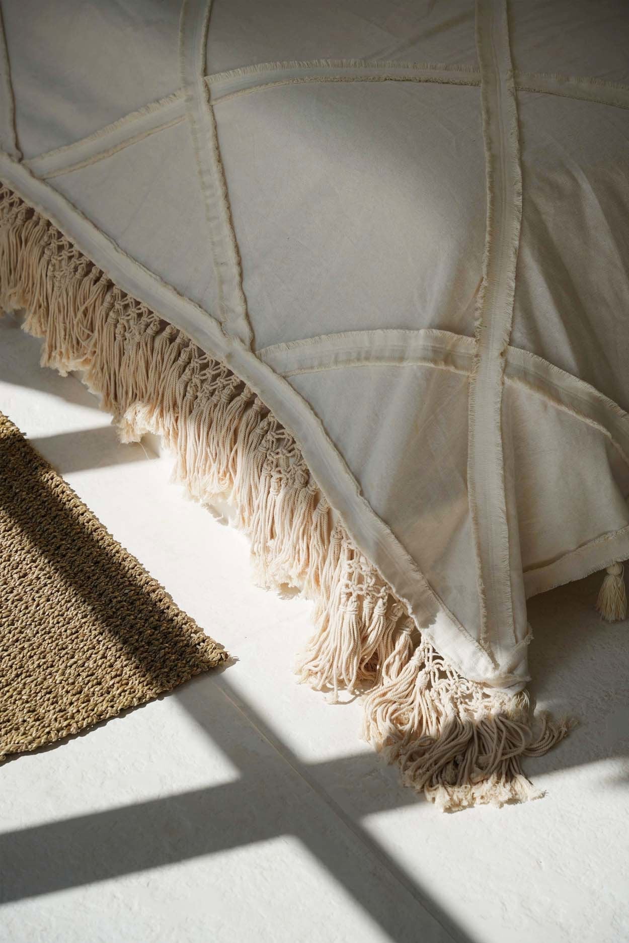 Kayu Living natural cotton Berber bed throw featuring a plush plaid pattern and decorative fringe edges.