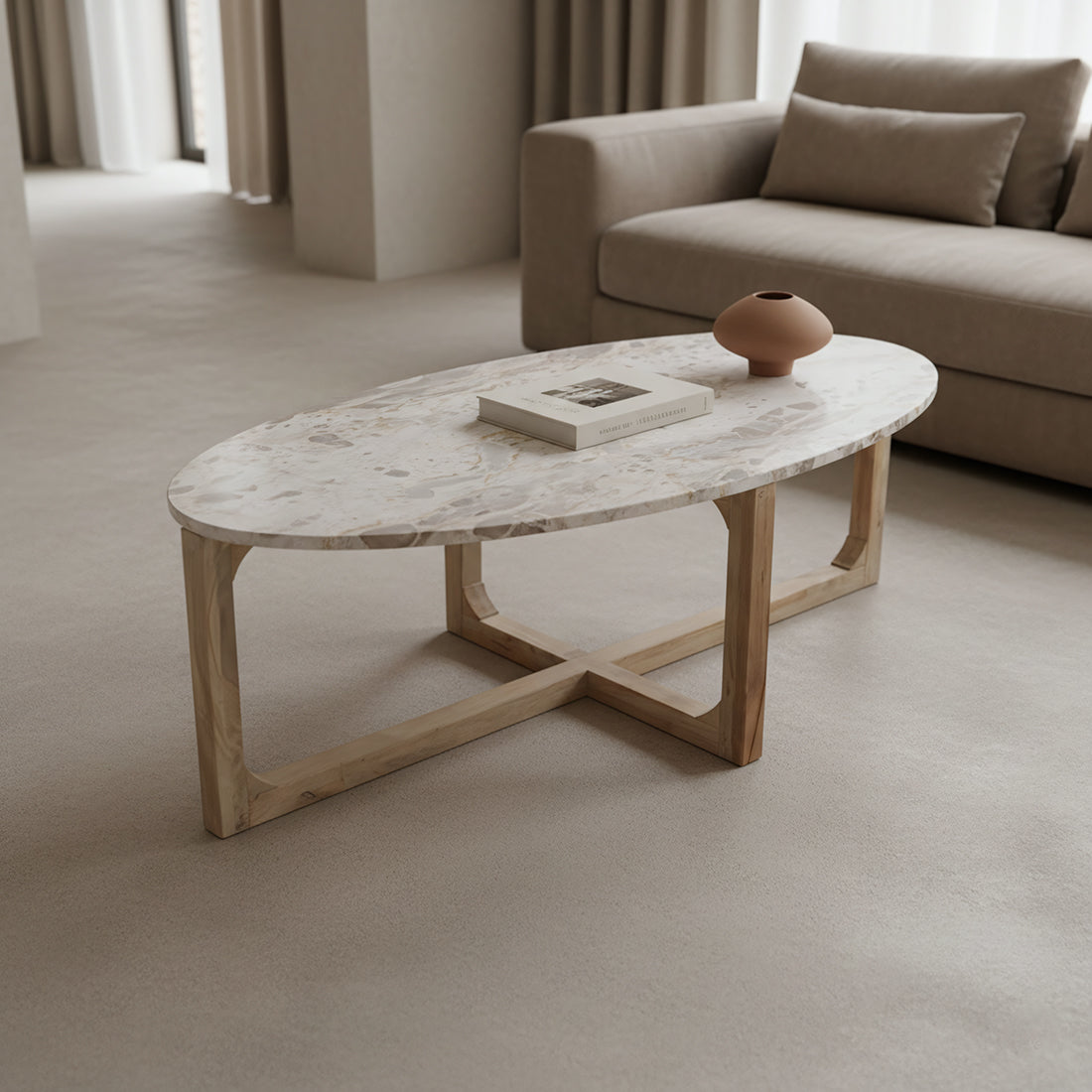 Kayu Living oval coffee table with a cream marble top and a sturdy light mango wood cross-base in a living room.