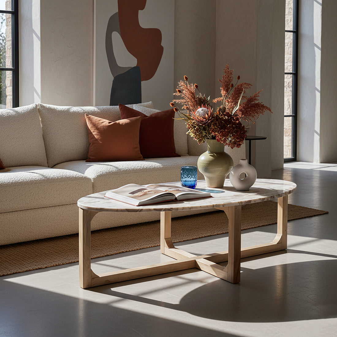Kayu Living oval coffee table with a cream marble top and a sturdy mango wood base in a bright, modern living room.