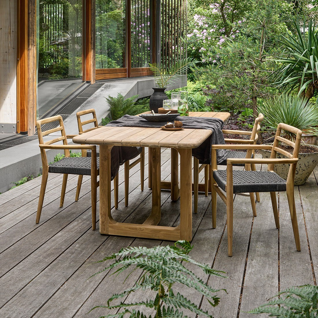 Kayu Living Primavera 240cm recycled teak garden table with rounded edges and U-shaped legs on a wooden deck