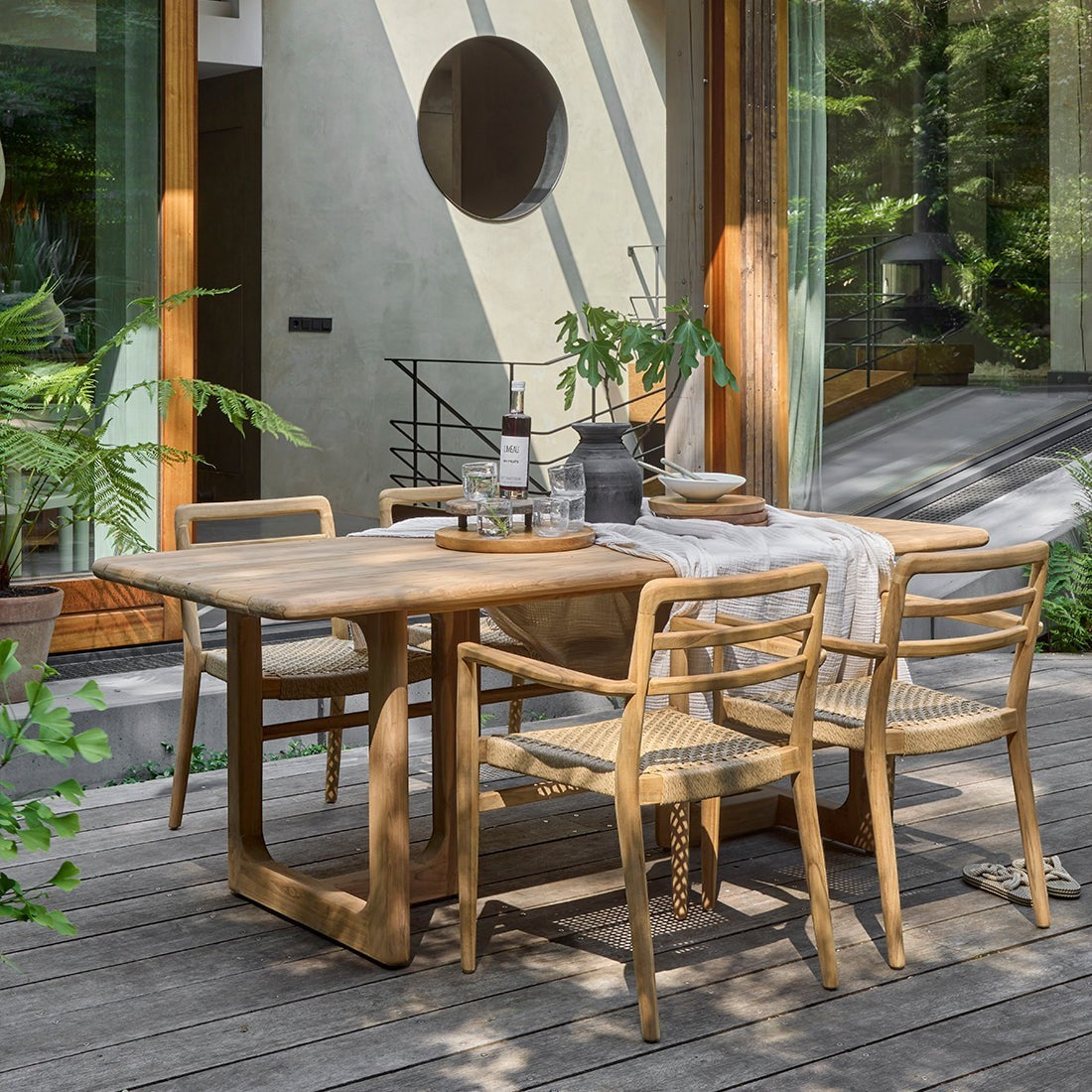 Kayu Living Primavera 240cm recycled teak garden table with rounded edges and U-shaped legs on a wooden deck.
