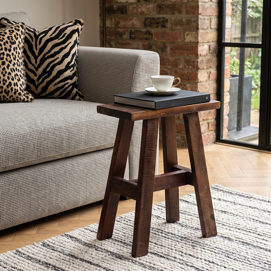 Kayu Living compact industrial wooden bench made from recycled wood with a warm patina, styled as a side table.