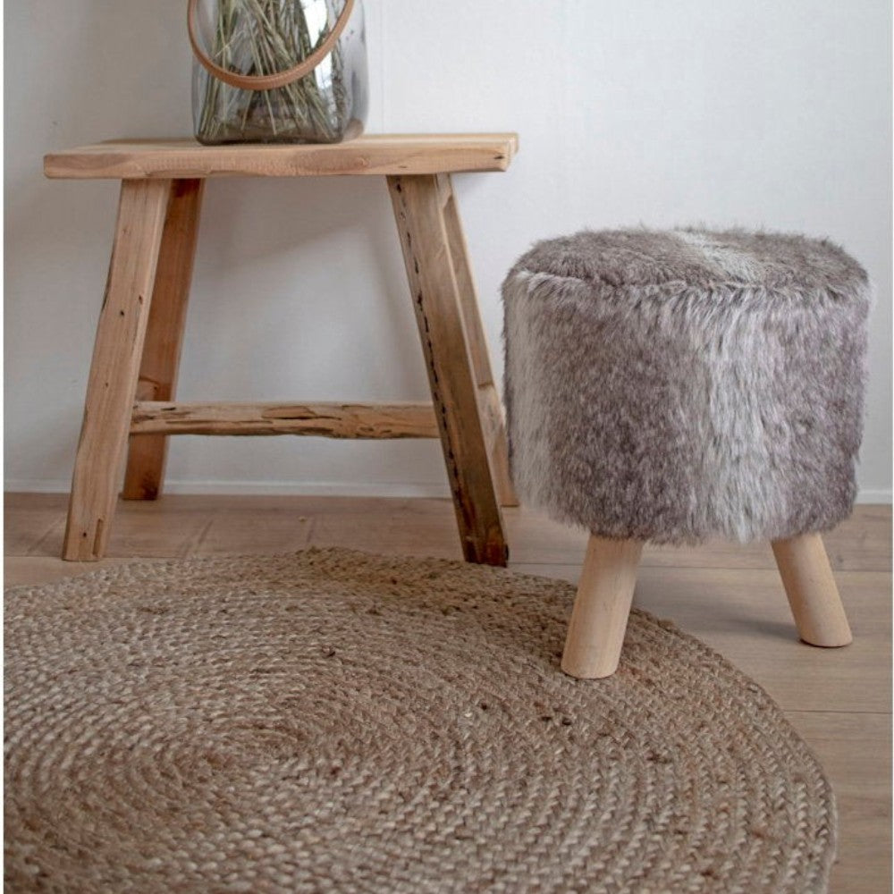 Kayu Living natural braided jute rug in a round 150cm design, styled with a wooden stool and dried flower vase.