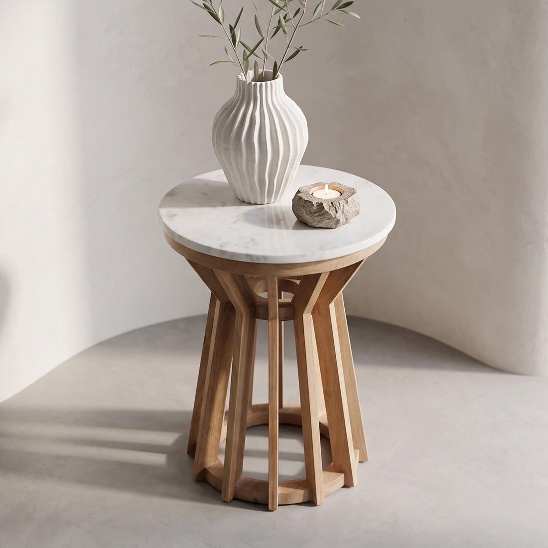 Kayu Living Sarawak round white marble side table with a natural mango wood base in a minimalist interior setting.