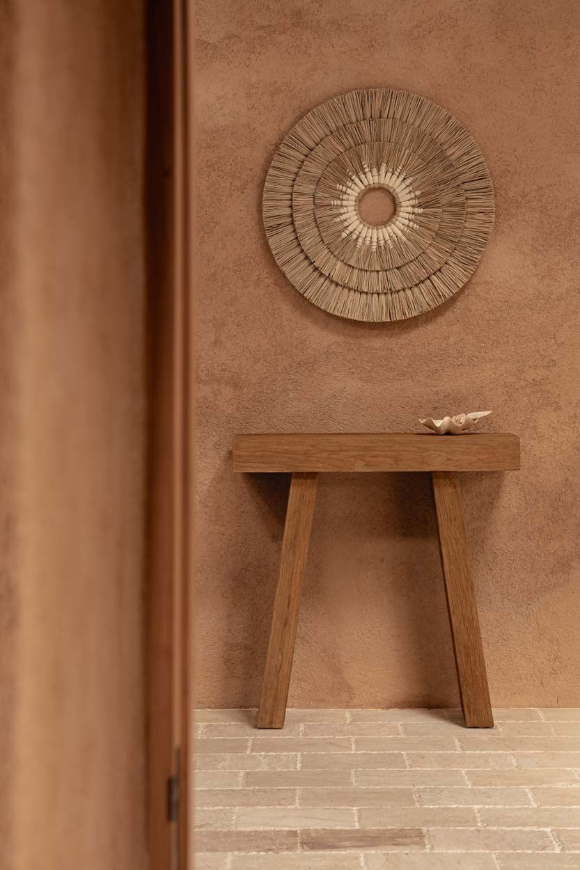 Kayu Living Stance Console table in natural teak wood with minimalist design against a textured terracotta wall.