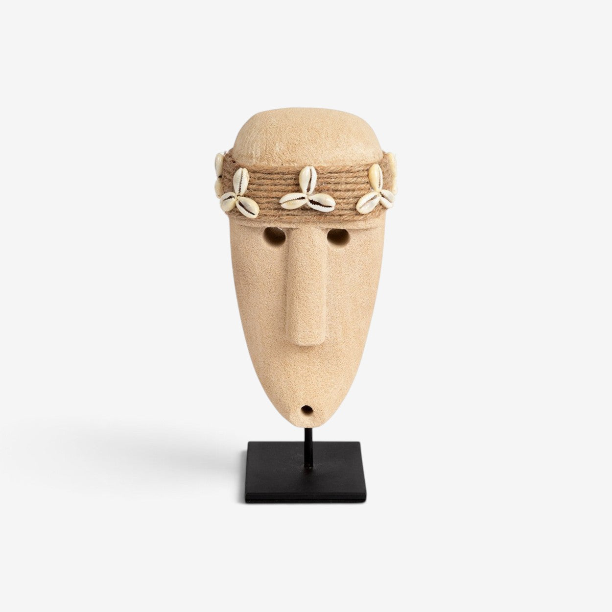 Kayu Living hand-carved sandstone Sumba stone figure with shell and twine detail on a black metal stand.