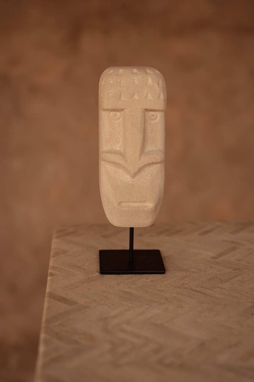 Kayu Living hand-carved sandstone Sumba statue on a black metal stand with natural beige tones.