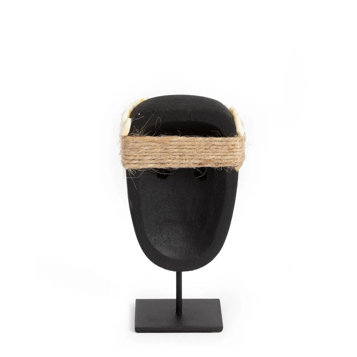 Kayu Living hand-carved black sandstone Sumba statue on a metal stand with decorative jute rope and shell accents.