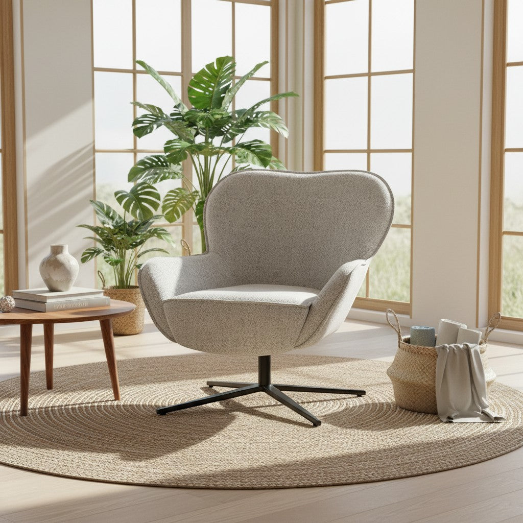 A modern swivel lounge chair upholstered in light beige textured fabric with a black metal star base, placed on a round woven rug in a bright, sunlit room with large windows, plants, and a small side table.