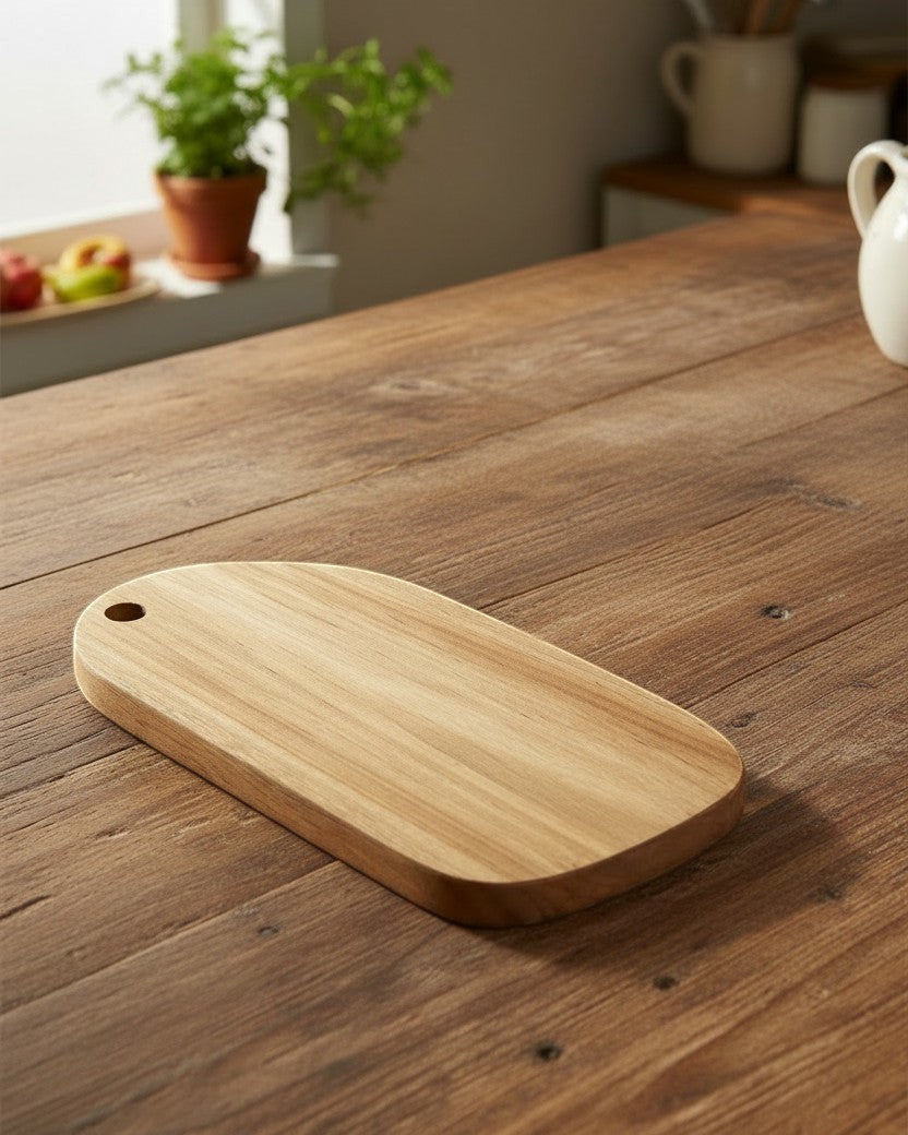 Kayu Living handcrafted teak wood cutting board with smooth finish and hanging hole. Ideal for kitchen prep.