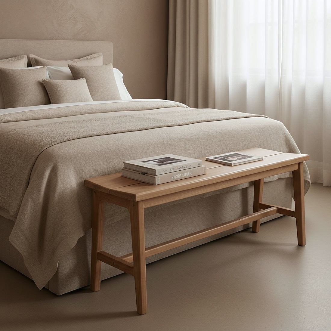 Kayu Living teak wood bench placed at the foot of a beige bed in a minimalist bedroom setting.
