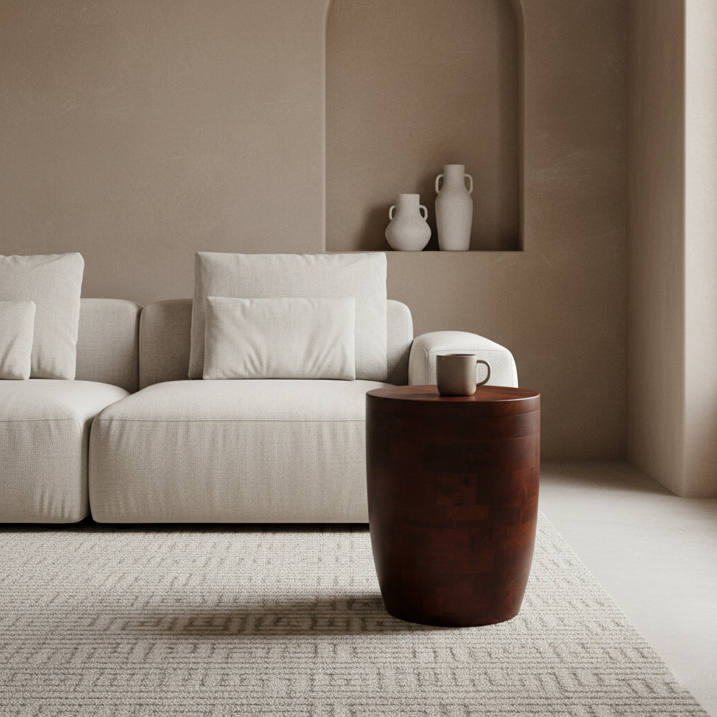 Kayu Living Tuvalu mango wood stool acting as a side table next to a beige sofa in a minimalist living room