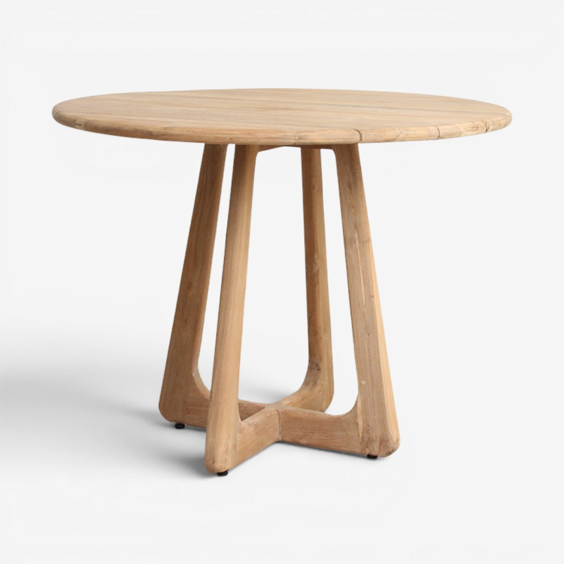Kayu Living Verano round teak dining table with a natural wood finish and sturdy cross-base design.