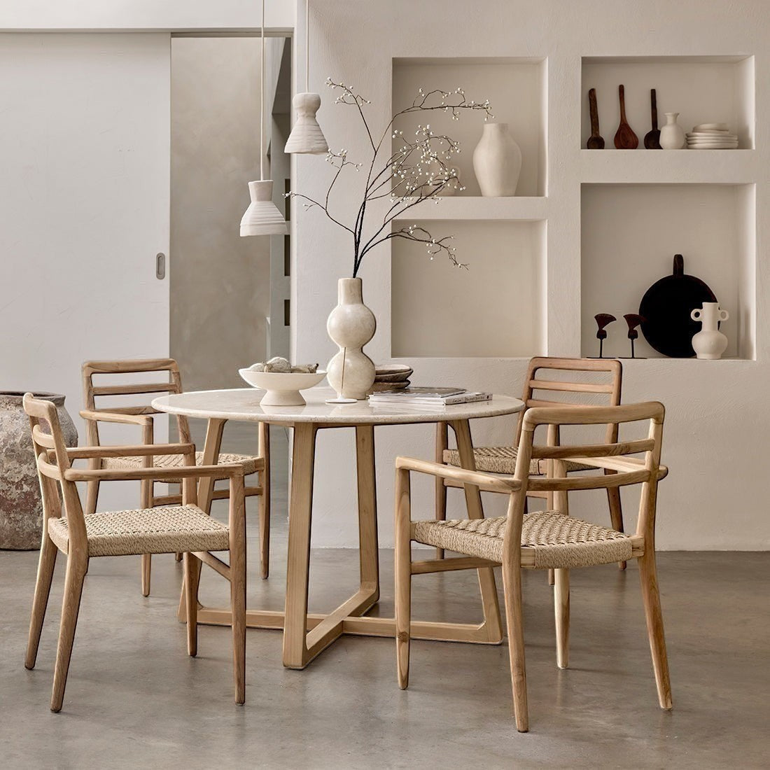 Kayu Living Verano teak garden chairs with armrests and woven rope seats arranged around a round dining table.