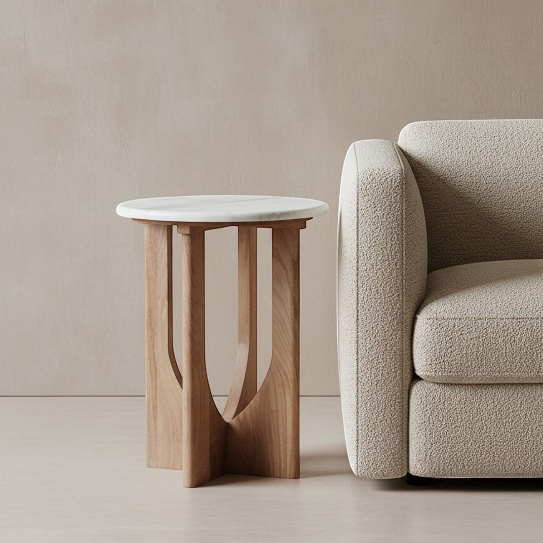 Kayu Living Kuching side table with a white marble top and arched mango-wood base next to a textured armchair.