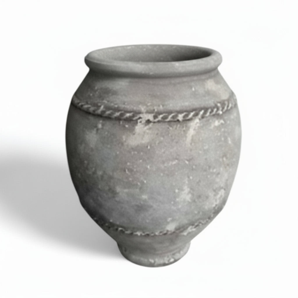 A vintage style terracotta pot with a grayish appearance and textured surface, featuring a larger opening at the top and a narrower belly, with another pot partially visible beside it.